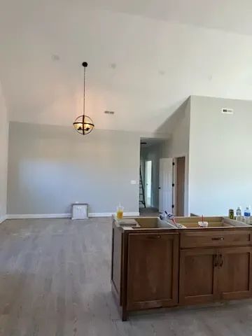 An empty kitchen with wooden cabinets and a sink.