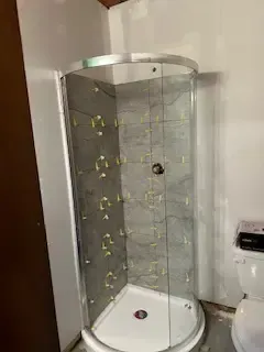 A bathroom with a shower stall and a toilet.