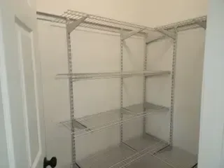 A walk in closet with shelves and a door.