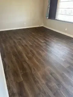 A living room with hardwood floors and a window.