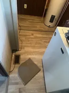 A laundry room with a water heater , washer and dryer , and a rug on the floor.