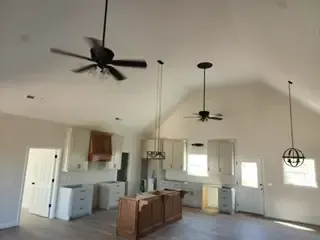 A kitchen with a ceiling fan hanging from the ceiling.