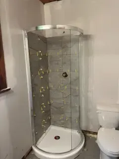 A bathroom with a shower stall and a toilet.