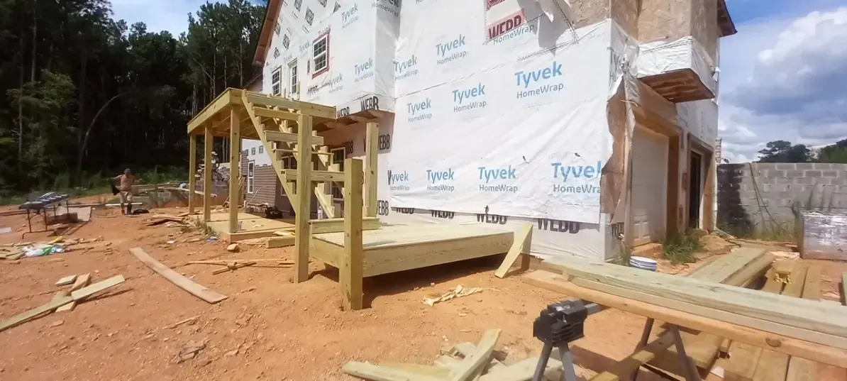 A house is being built in the middle of a dirt field.