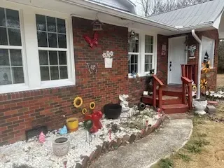 A brick house with a walkway leading to the front door.