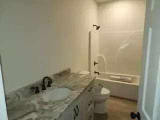 A bathroom with a sink , toilet , bathtub and shower.
