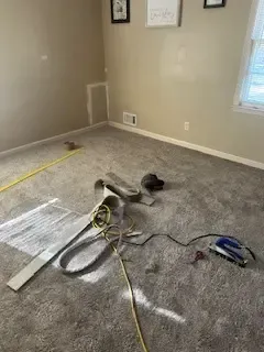 A room with a carpet and a tape measure on the floor.