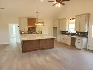 An empty kitchen with a large island in the middle of the room.