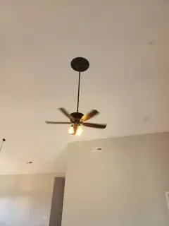 A ceiling fan is hanging from the ceiling of a room.