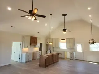 A kitchen with a vaulted ceiling and a ceiling fan.