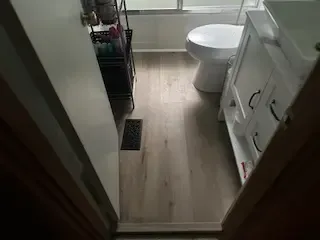 A bathroom with a toilet , sink , and shower.
