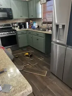 A kitchen with a refrigerator , stove , sink , and microwave.
