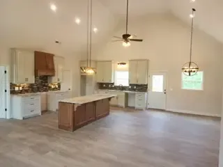 An empty kitchen with a large island in the middle of the room.