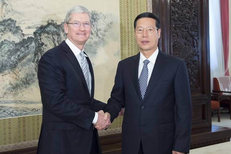 two men in suits shaking hands with friendly expressions