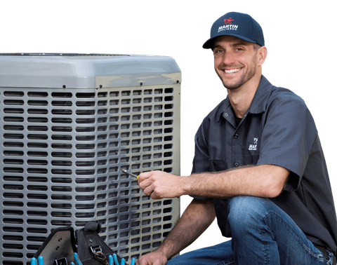 A man is kneeling down next to an air conditioner while working on it.