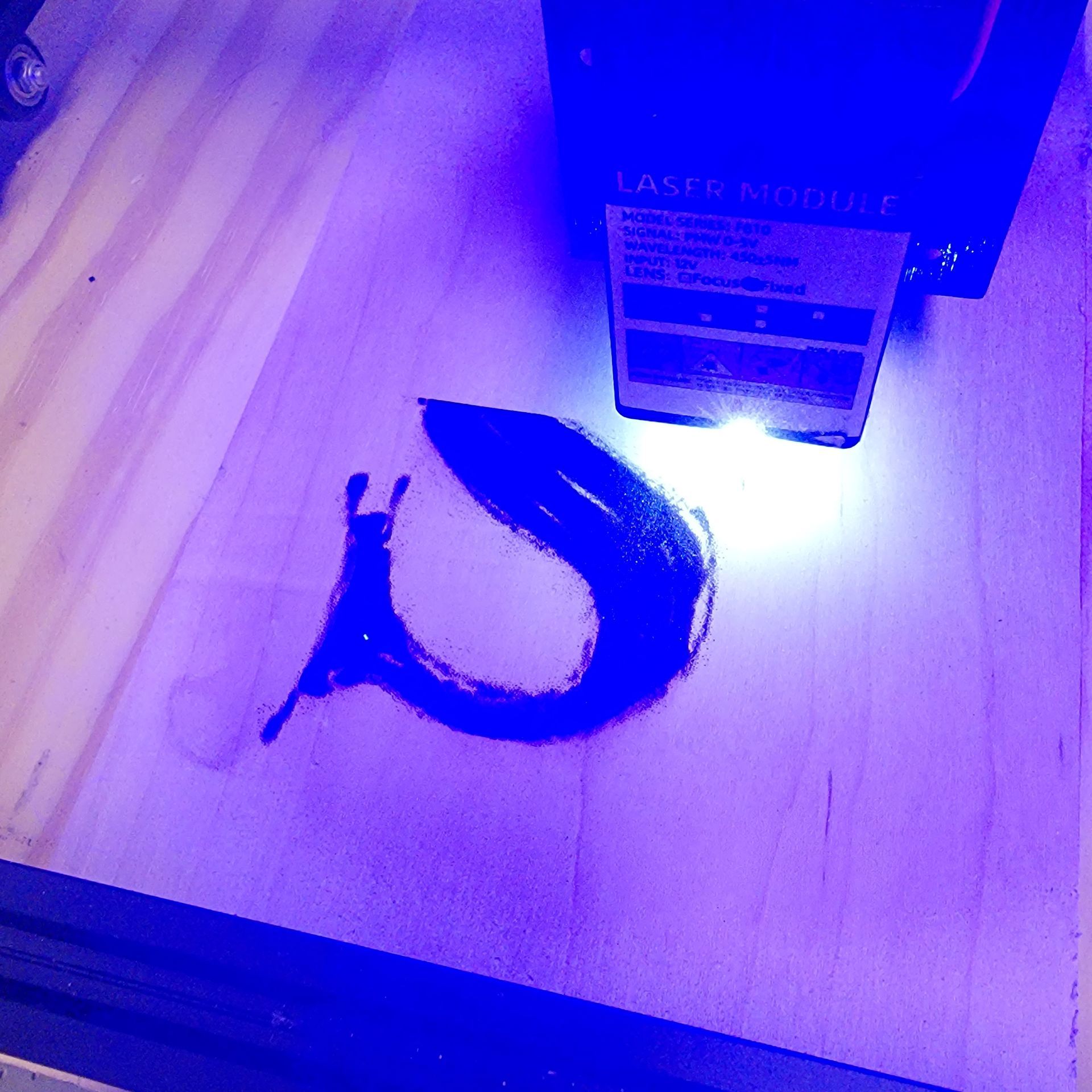 Laser engraver burning a stylized 