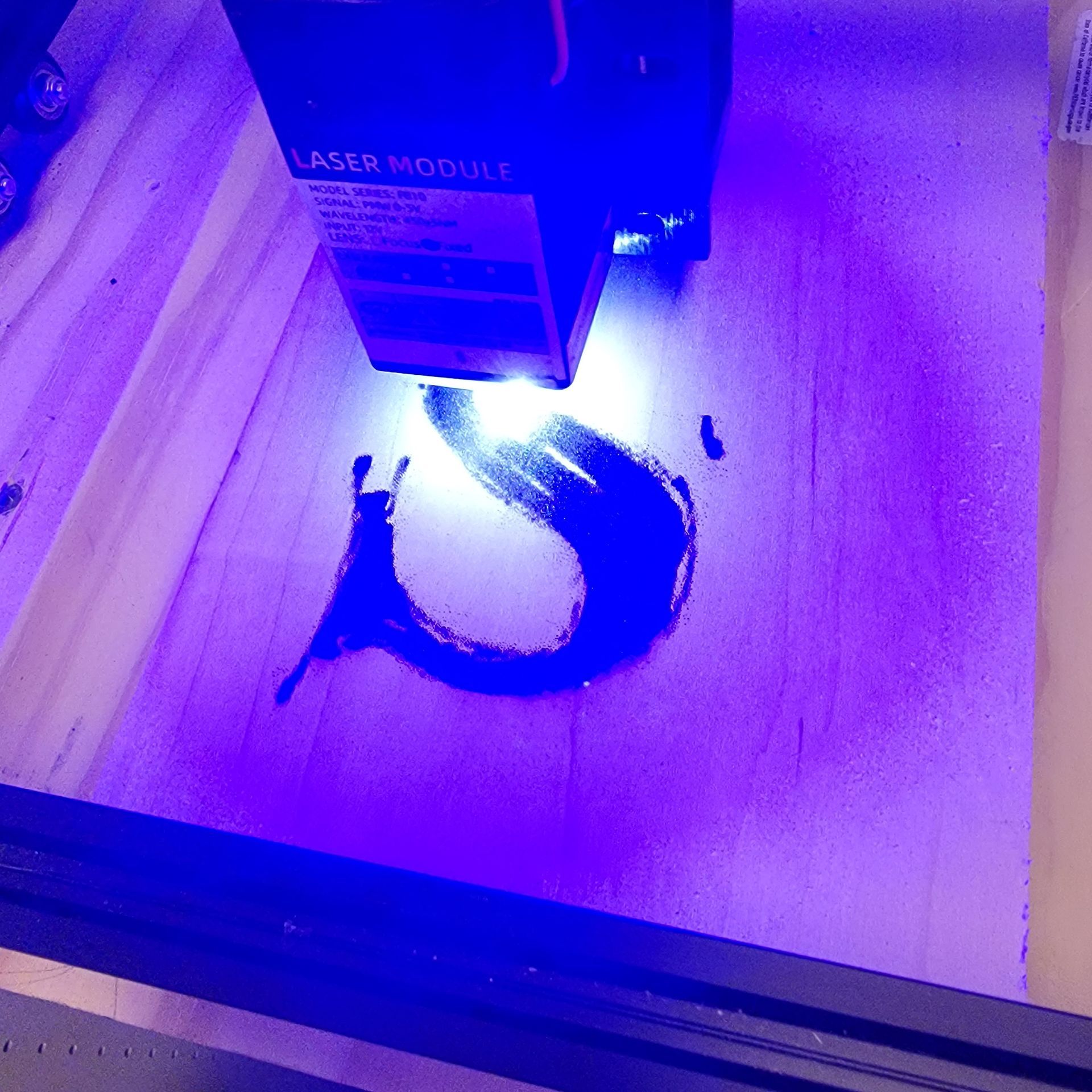 Laser engraver etching a black 