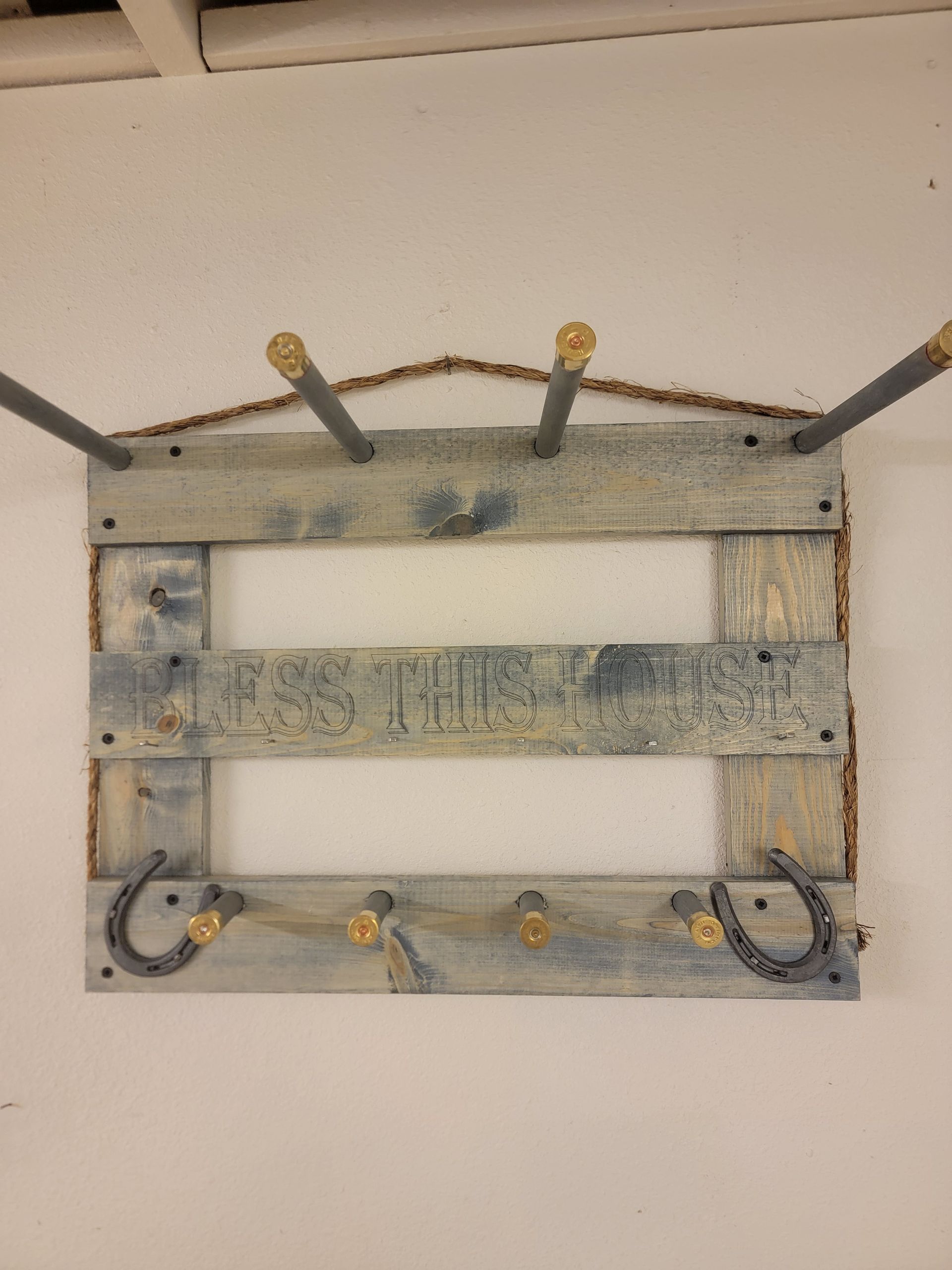 Rustic wooden wall organizer with hooks and metal rods.