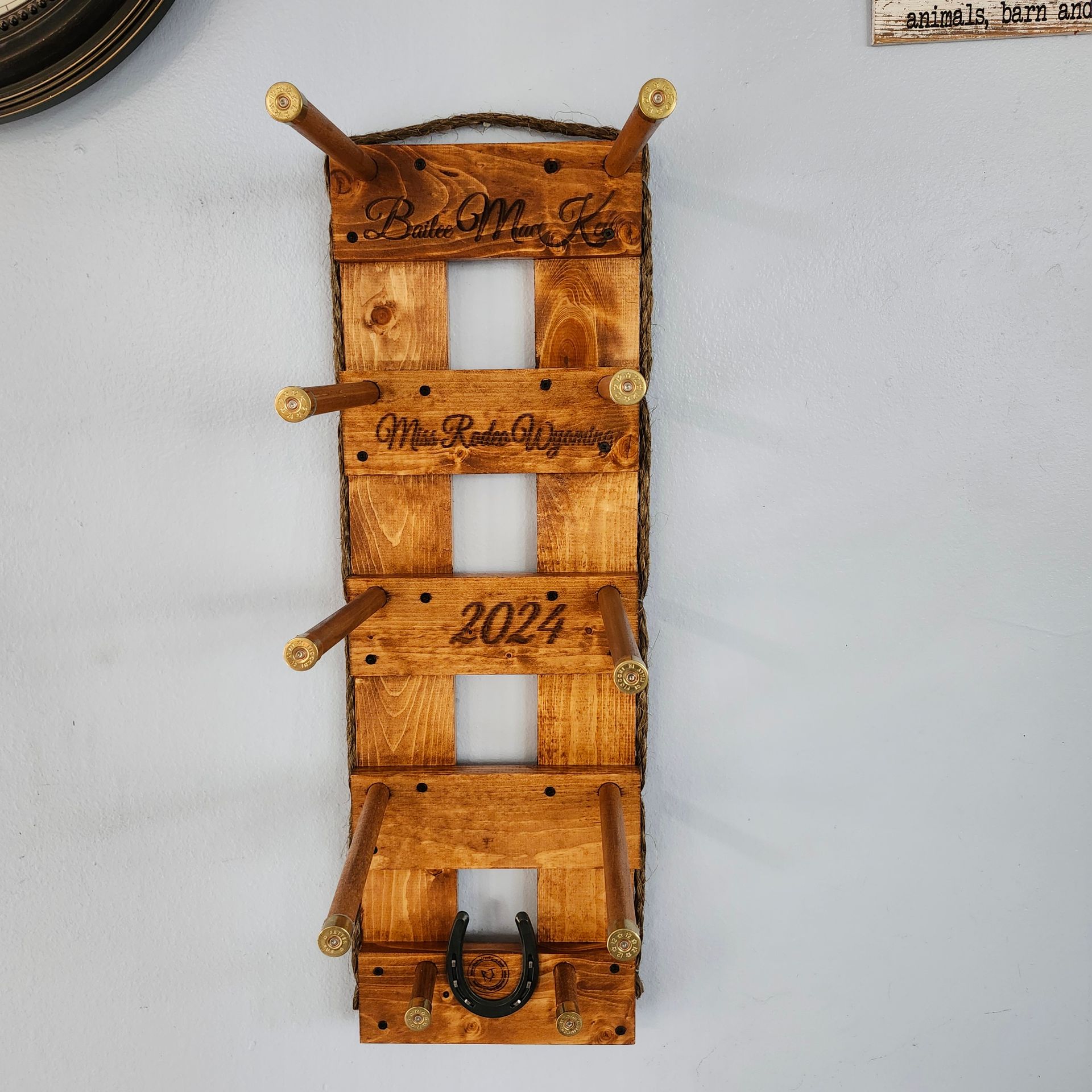 Wooden wine rack with engraved text and horseshoe decoration.