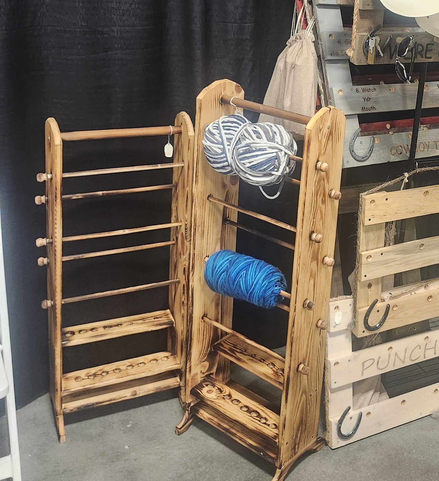 Wooden yarn racks with balls of yarn.