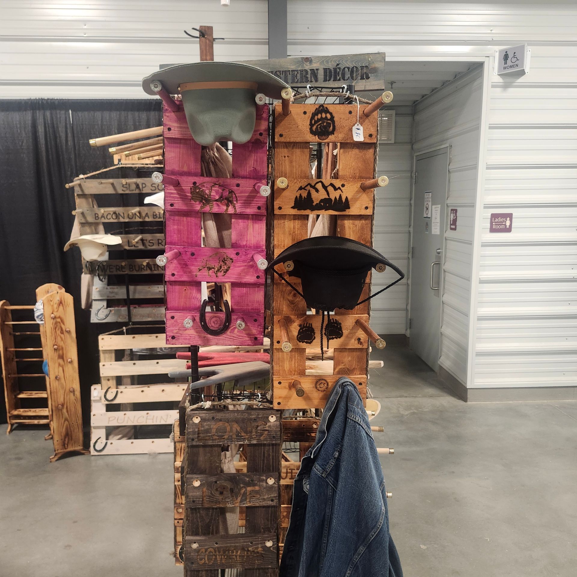 Wooden display stand with hats and decor at an event.