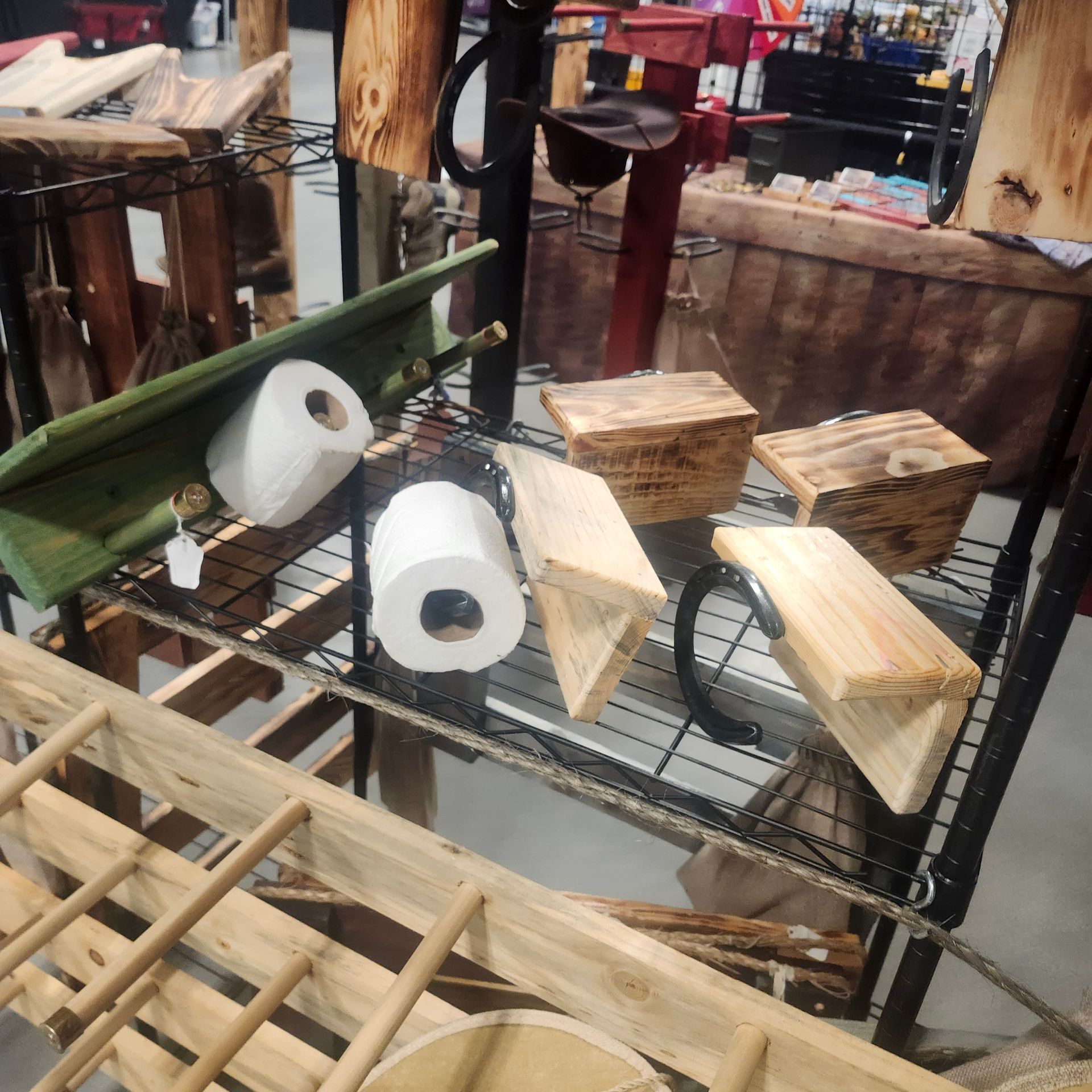 Rustic wooden home decor on display: shelves, boxes, toilet paper holders, and a small ladder.