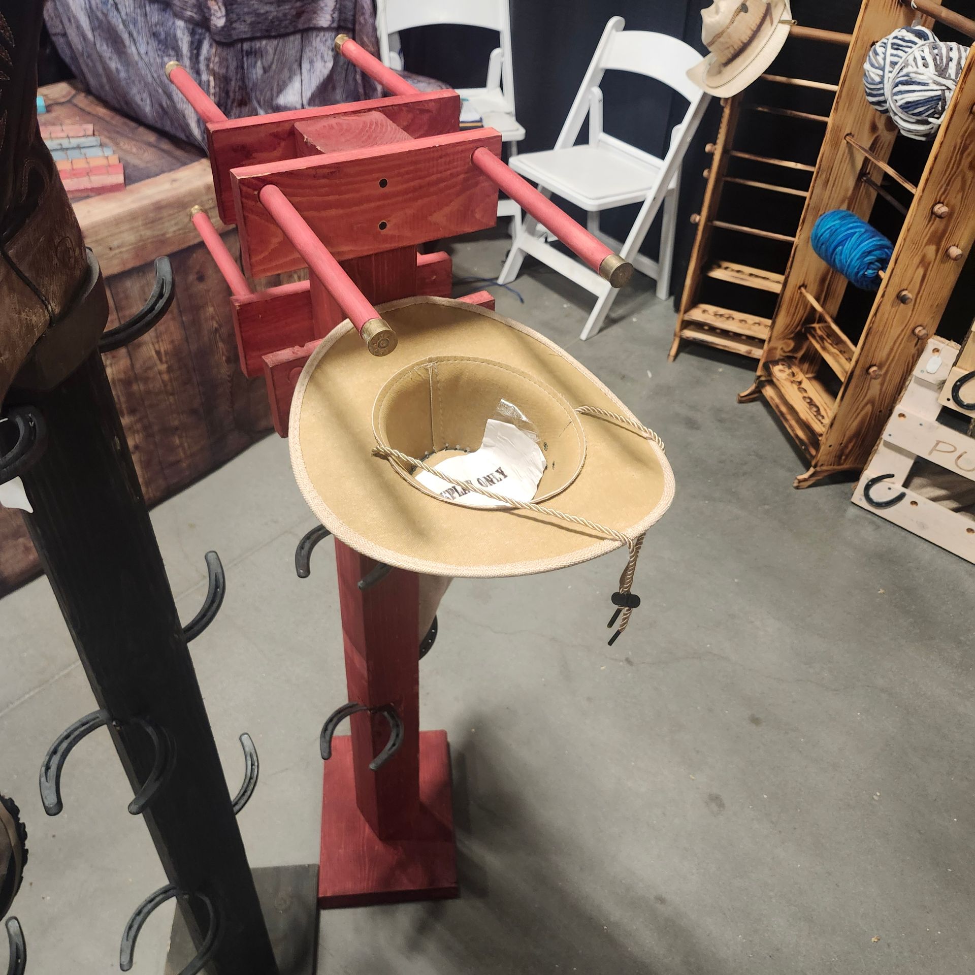 Red wooden hat stand with a cowboy hat on display in a store.