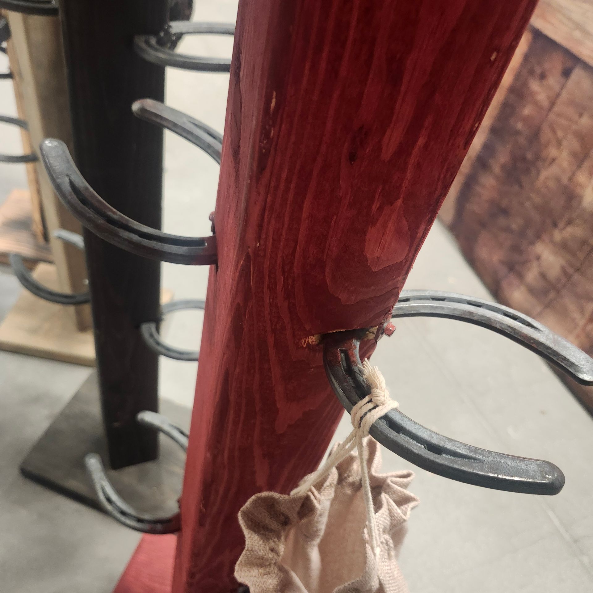Red and black horseshoe wine rack. The red one has a small bag hanging from a horseshoe.
