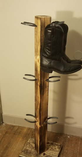 Wooden boot rack with metal holders, displaying one black cowboy boot.