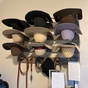 Hat rack holding various hats; brown, black, and tan, with accessories hanging below.