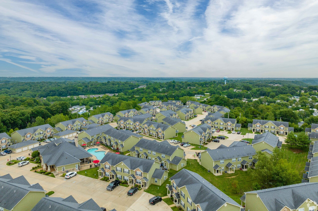 An aerial view of a residential area with lots of houses and a pool.