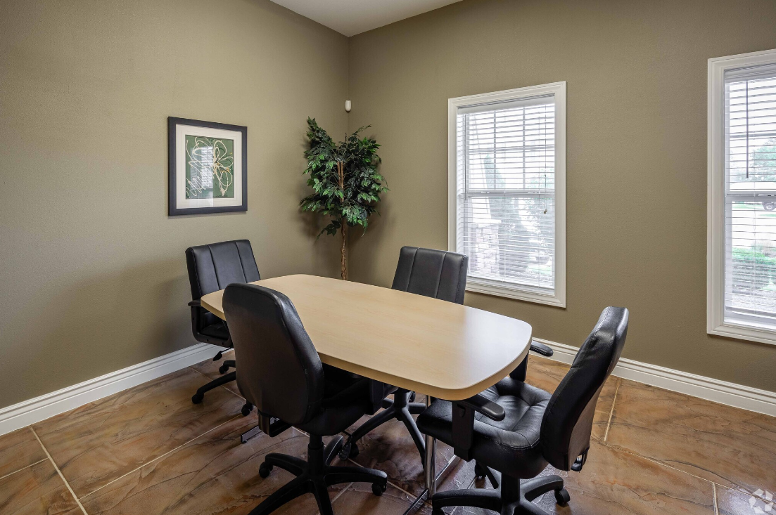 A conference room with a long table and chairs.