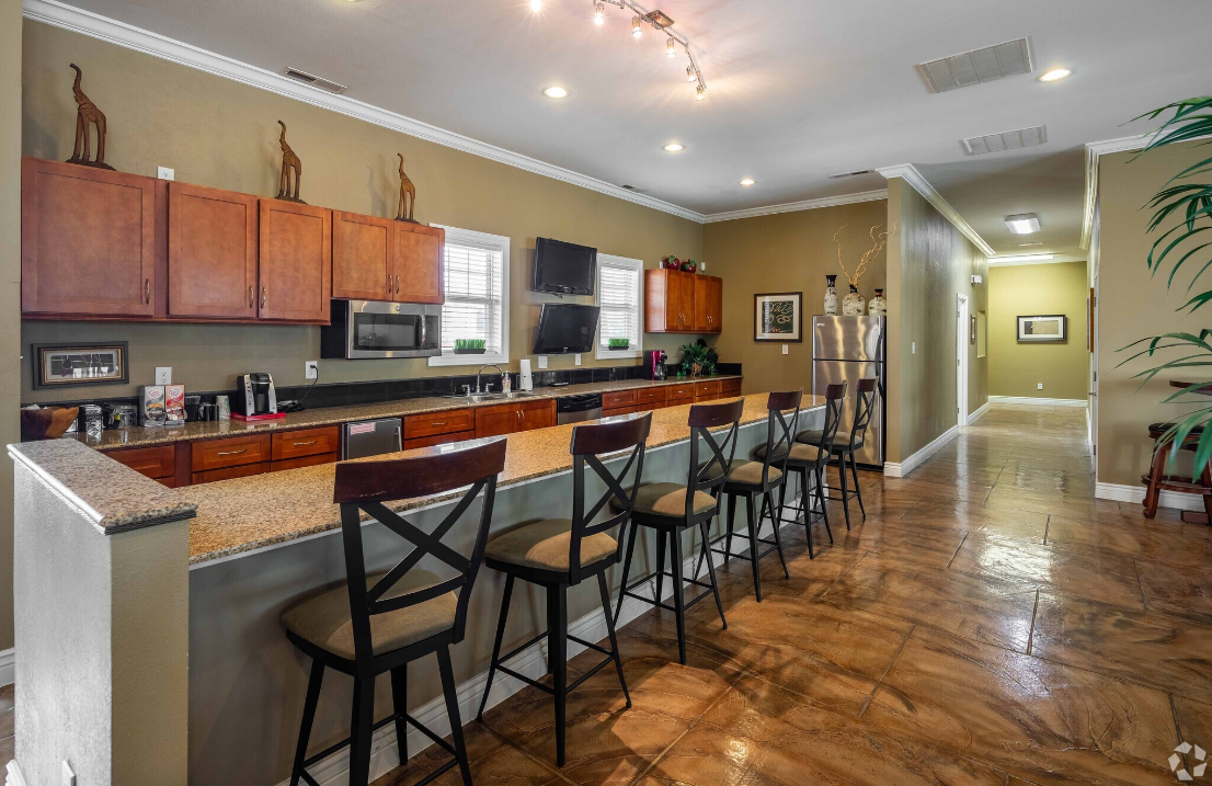 A kitchen with a bar and chairs in it