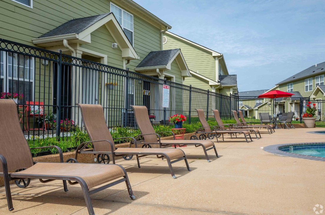 A row of lounge chairs sitting next to a swimming pool.