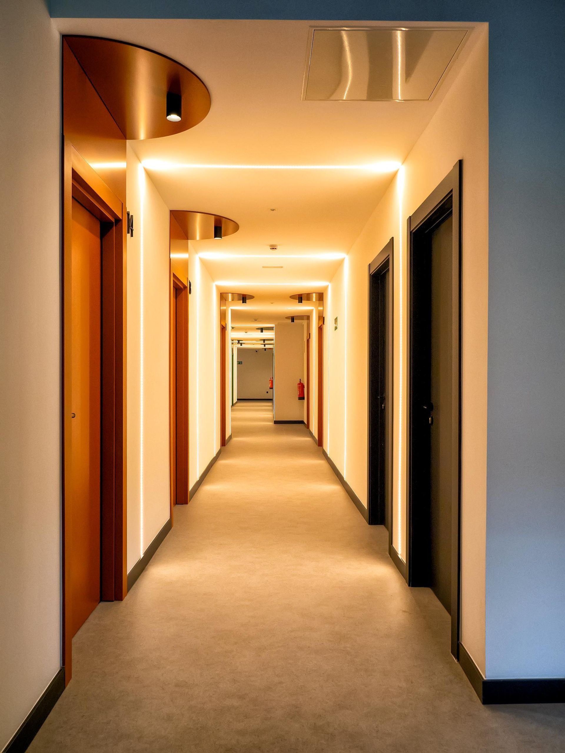 A long hallway with a lot of doors and lights