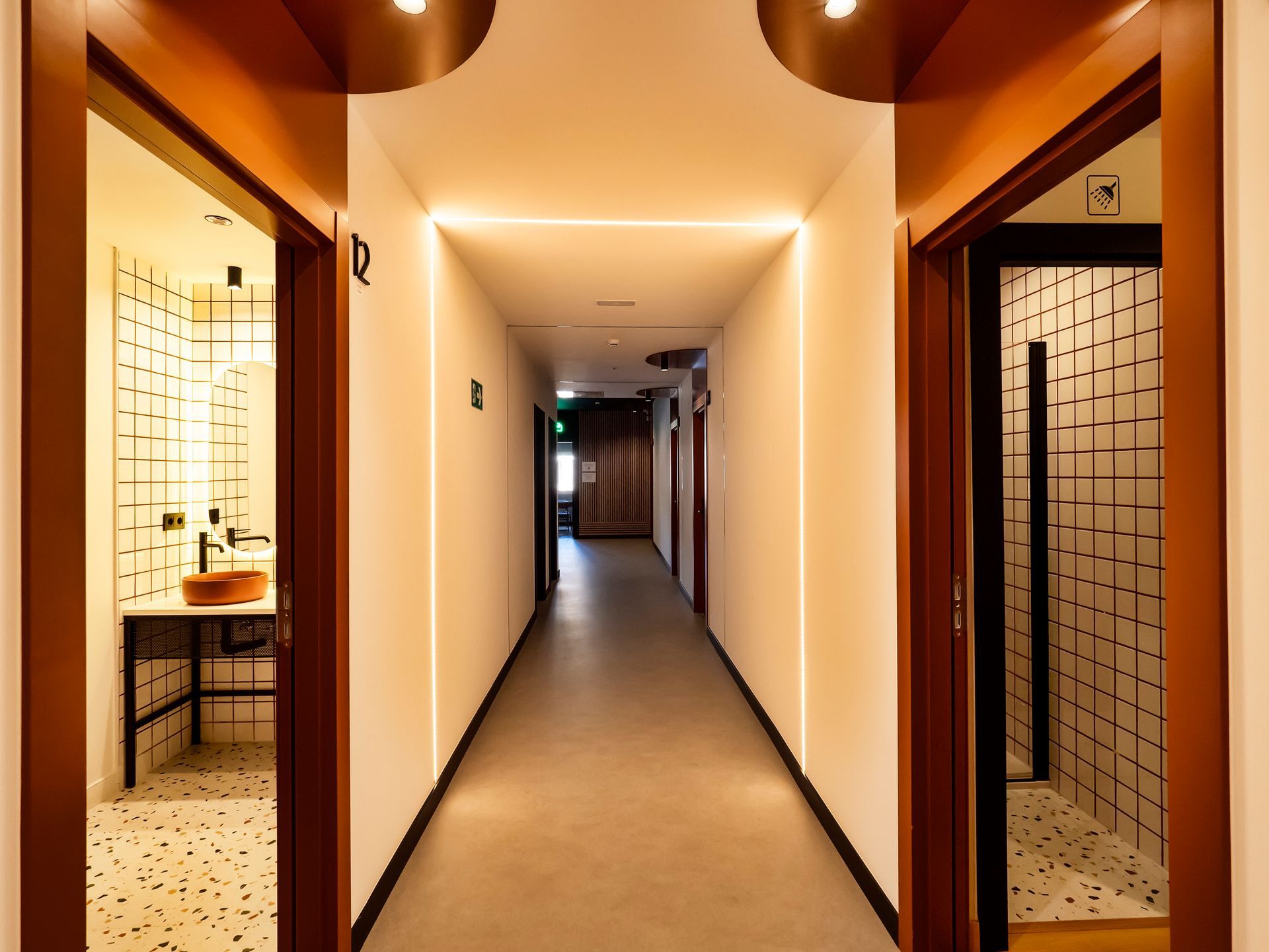 A long hallway leading to a bathroom and a sink