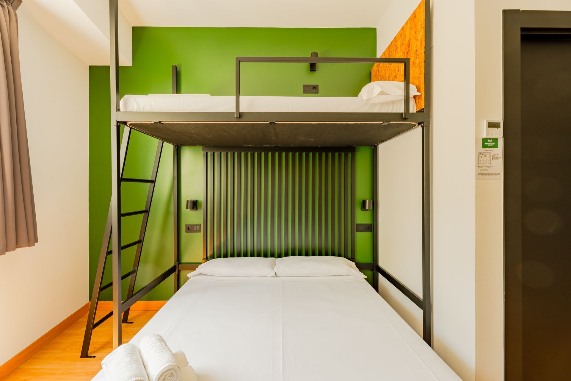 A hotel room with a bunk bed and a ladder