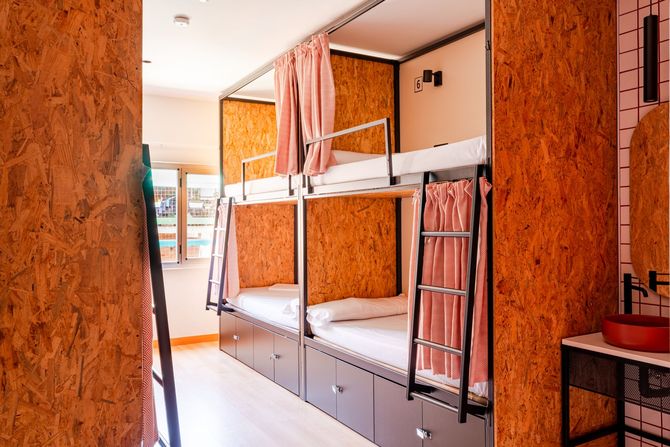 A bunk bed room with two sinks and two mirrors.