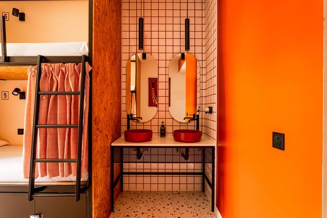 A room with bunk beds and a bathroom with a shower.