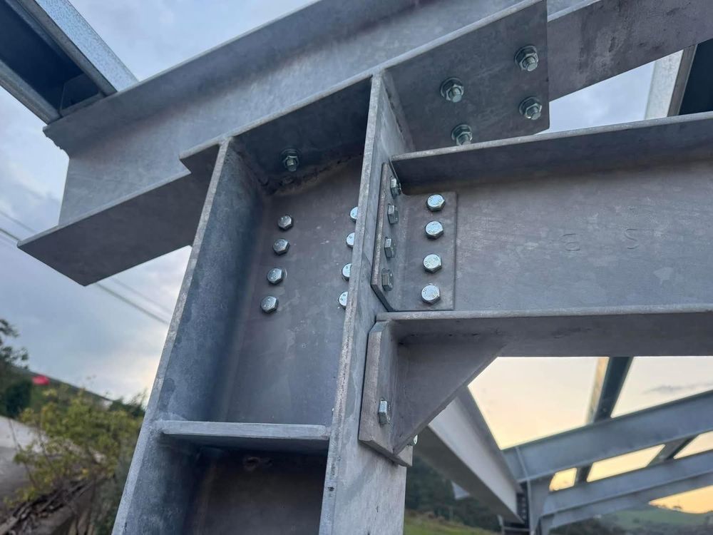 Travi in ​​acciaio imbullonate tra loro, a formare una struttura portante. Struttura in metallo zincato con bulloni a vista.