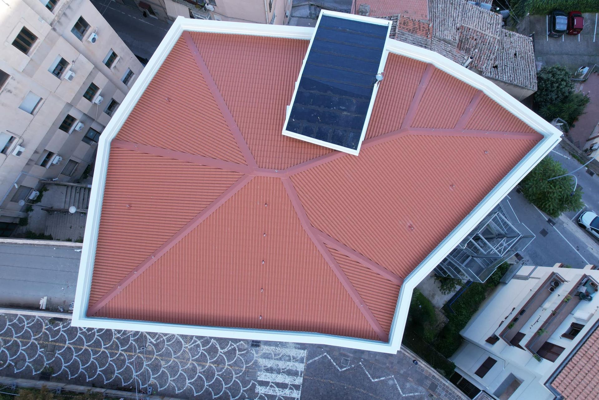Vista dall'alto di un tetto di tegole rosse con un pannello solare.