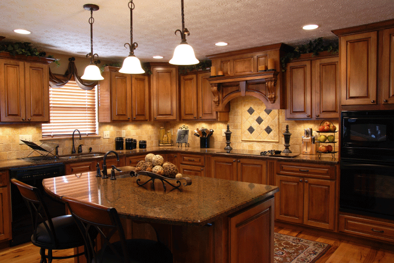 Gray kitchen cabinetry with glass-paneled upper cabinets, a granite countertop, and a coffee machine.