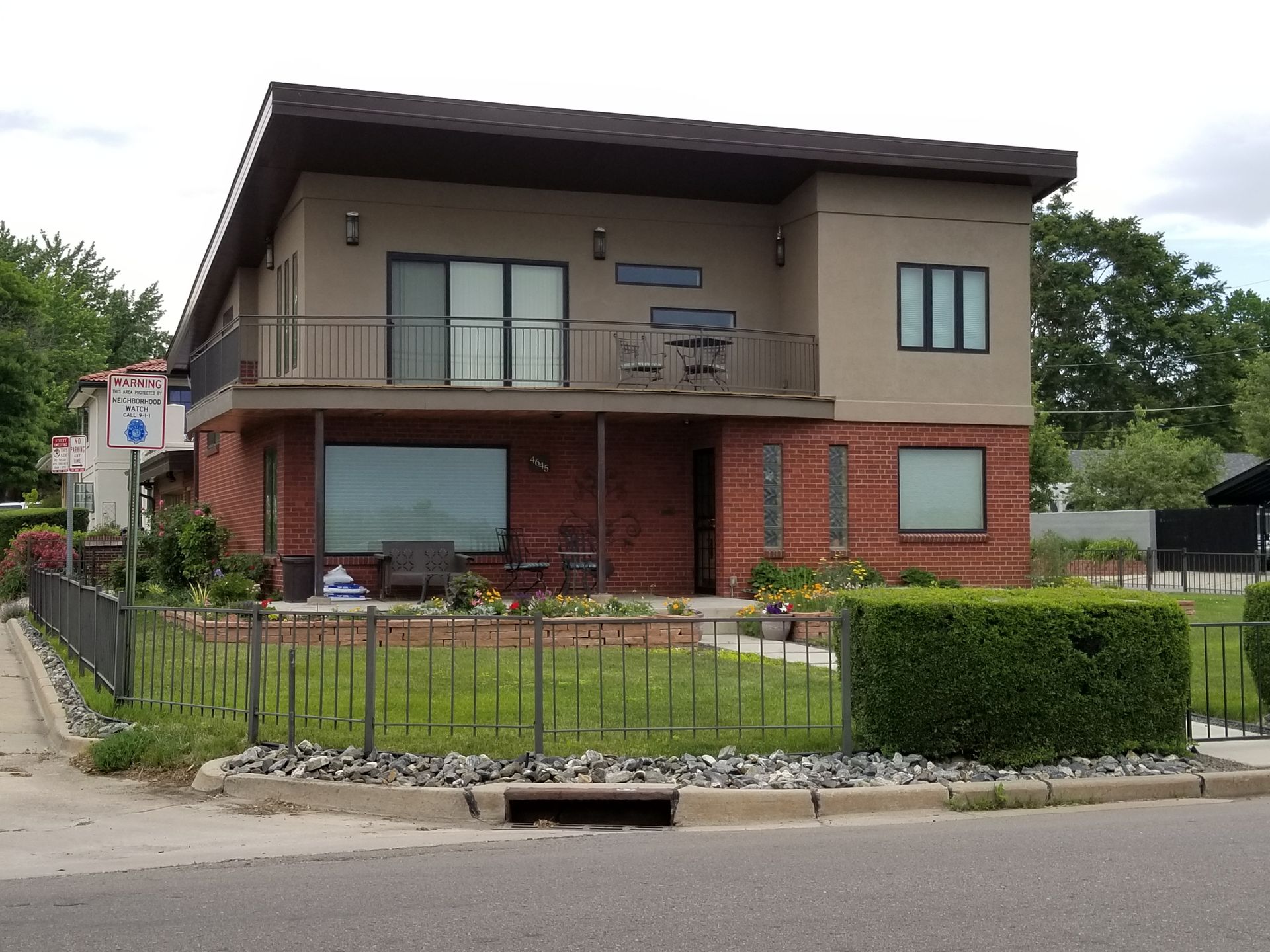 House exterior with gray siding and light-colored trim. Sliding glass door and two windows are visible.