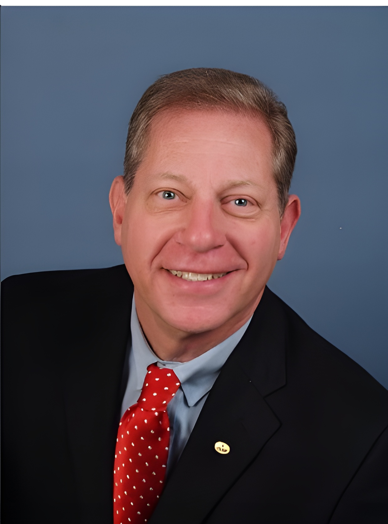 steve goldstein in a suit and tie is smiling for the camera