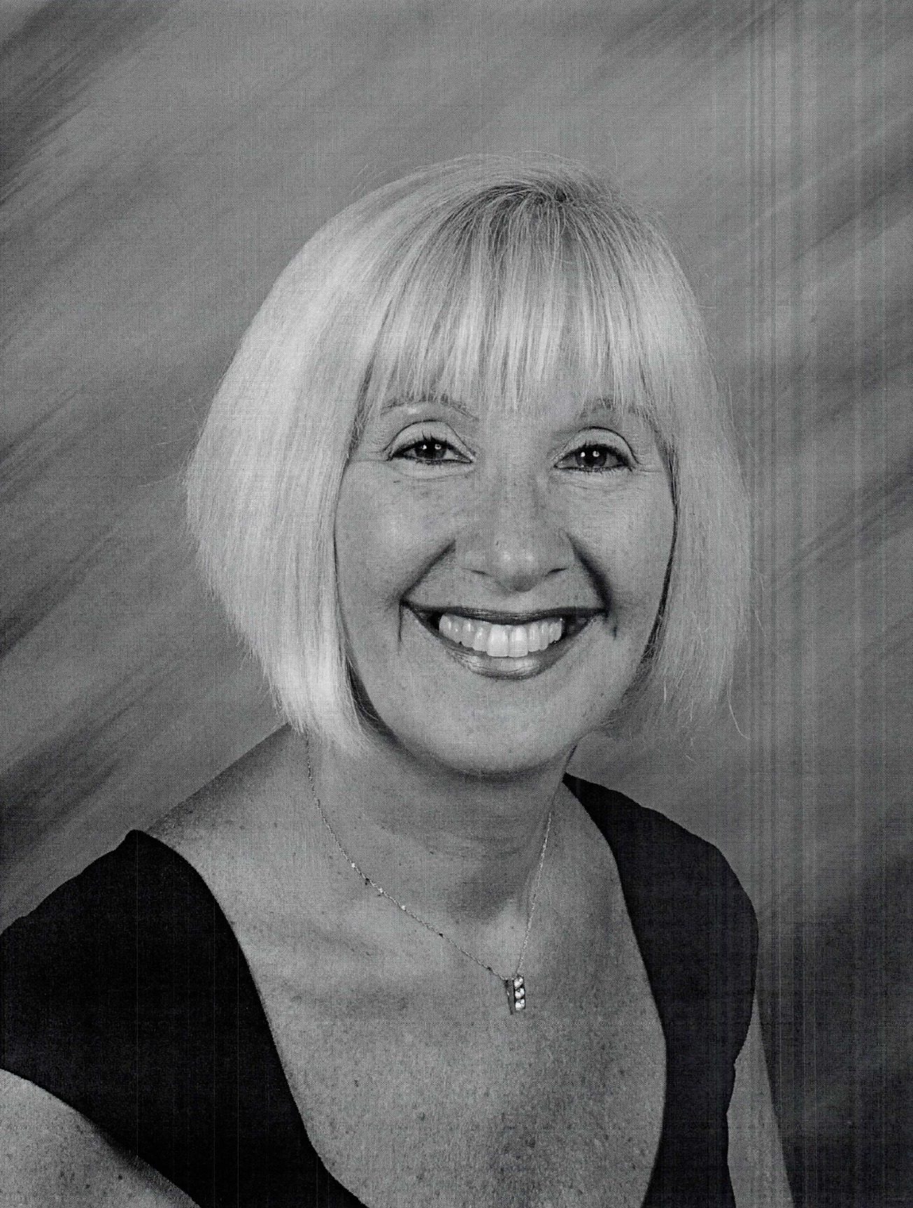 A black and white photo of sherry goldstein smiling and wearing a black shirt.