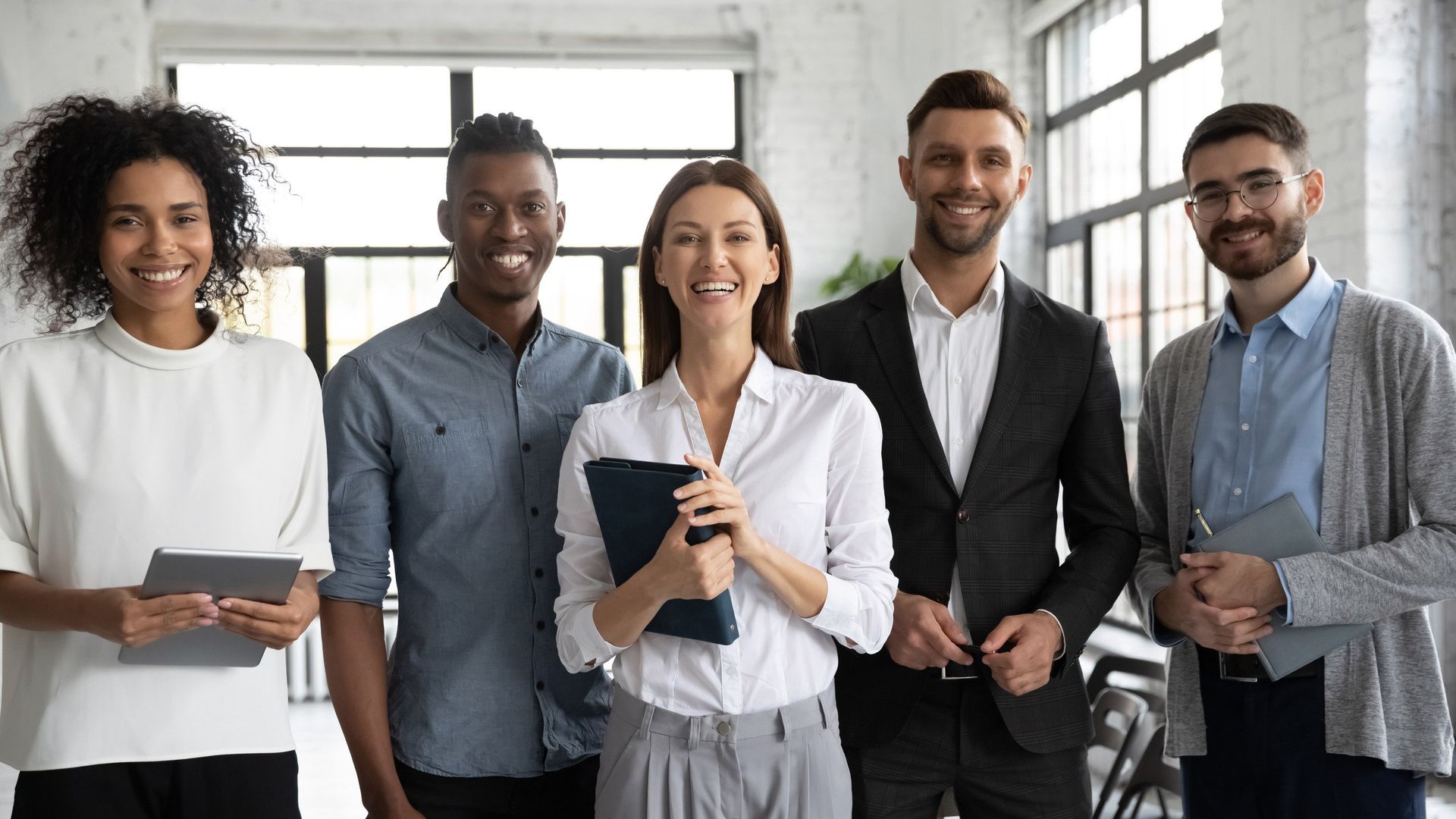 A group of people are standing next to each other in an office.