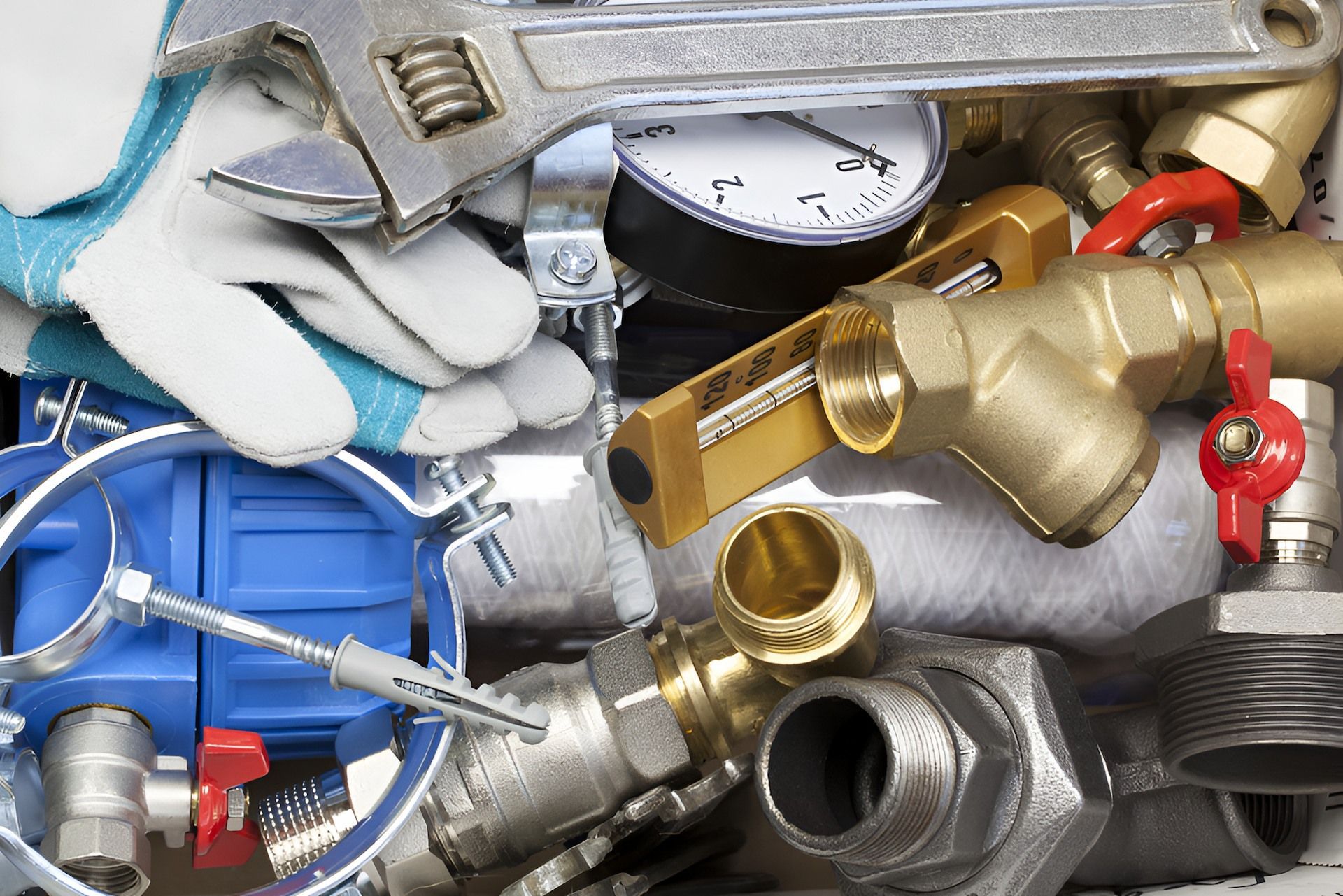 A Person is Holding a Wrench Over a Pile of Pipes and Valves — Around Town Plumbing Services in Gungahlin, ACT
