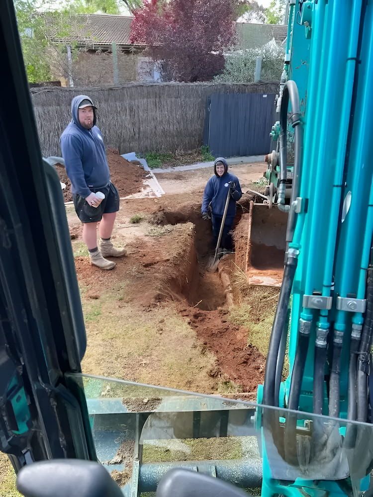 A Man is Digging a Hole in the Ground With a Shovel β Around Town Plumbing Services in Canberra, ACT