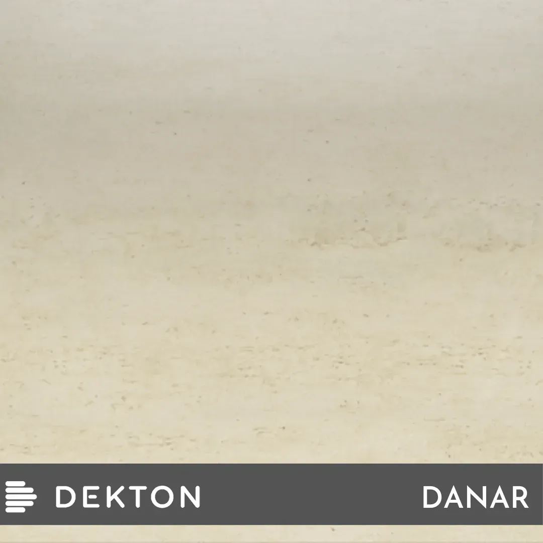 Superficie texturizada de color beige con una etiqueta DEKTON DANR de color gris oscuro a lo largo del borde inferior.