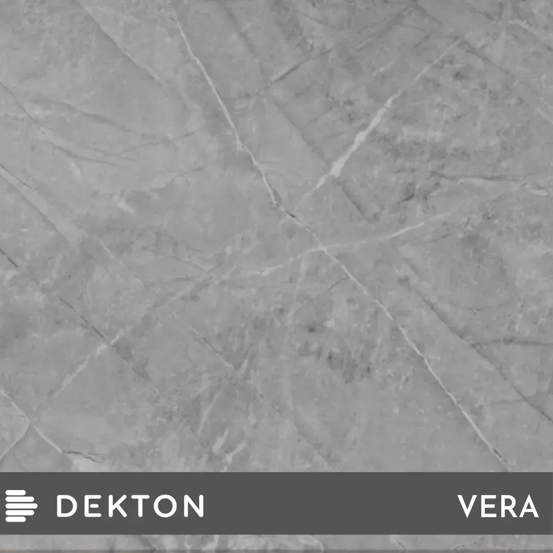 Superficie gris con aspecto de piedra y sutiles vetas diagonales, etiquetada como “DEKTON VERA” en la parte inferior.
